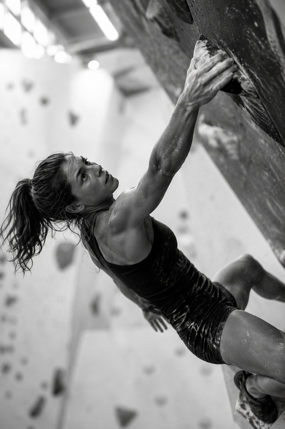 Athlete bouldering, reaching for a hold