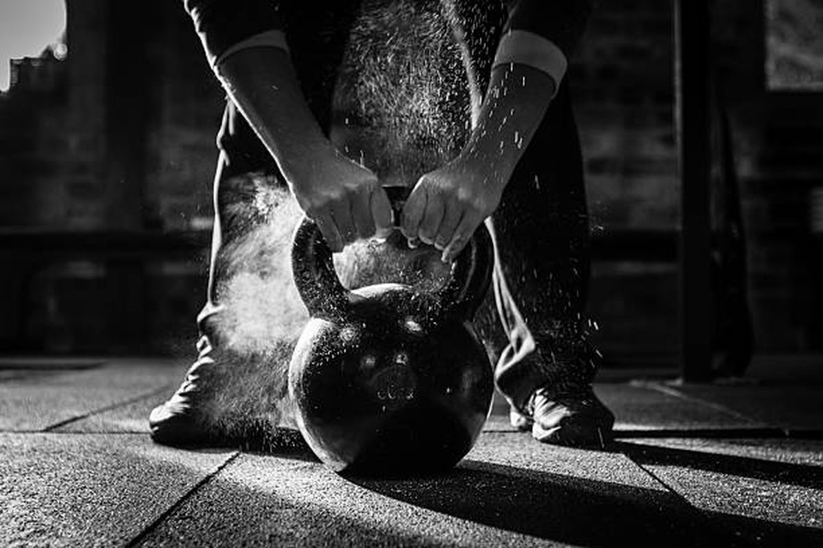 Athlete chalking hands before a kettlebell lift